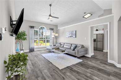 Living room featuring a ceiling fan, wood finished floors, and a textured ceiling