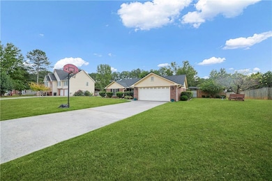 Ranch-style home featuring extended driveway, and an attached garage
