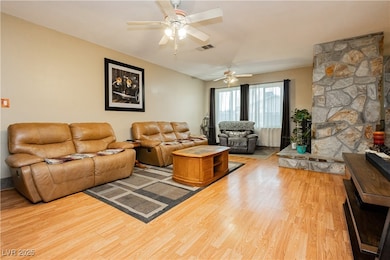 Living area featuring a ceiling fan and wood finis
