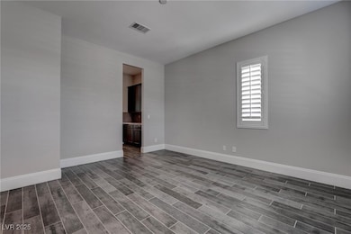 Spare room with baseboards, dark wood-style floors
