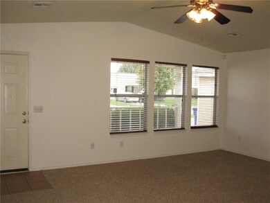 Ample windows with faux wood blinds create the per