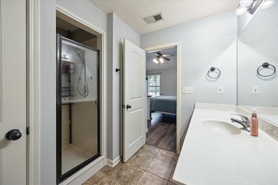 Enclosed shower, vanity, and tile flooring.