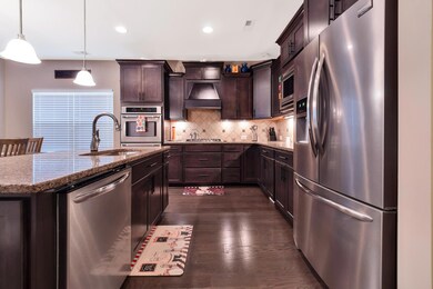 Kitchen features soft close cabinets, auto sensing faucet, gas stove, granite counters, tile backsplash and more