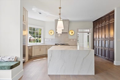 Kitchen featuring light stone countertops, light h