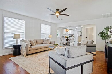Living area with dark wood-type flooring and ceiling fan