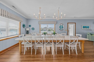 Dining space featuring a chandelier, crown molding, wood finished floors, and wooden walls
