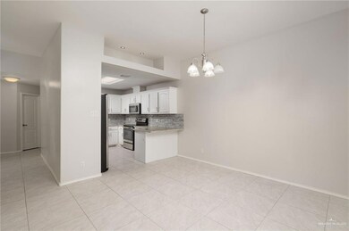 Kitchen featuring a peninsula, backsplash, hanging light fixtures, appliances with stainless steel finishes, and white cabinets