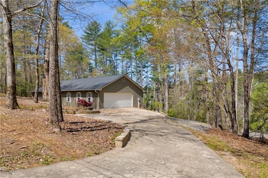 View of side of property with a garage and aphalt driveway