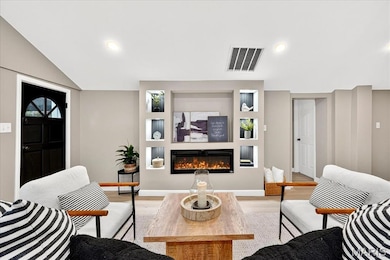 Living area featuring wood finished floors, an electric fireplace, and recessed lighting