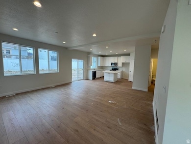 Unfurnished living room featuring recessed lighting, light wood finished floors, and a textured ceiling
