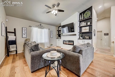 Living room featuring a large fireplace, ceiling f