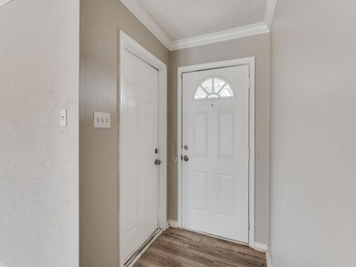 Doorway to outside featuring a textured ceiling, a