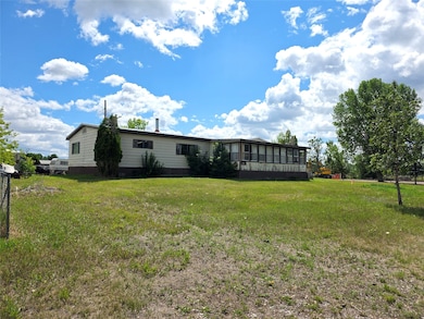Back of house featuring a sunroom and a lawn