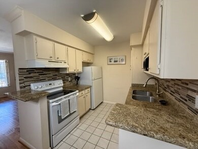 This kitchen features granite countertops, a tile