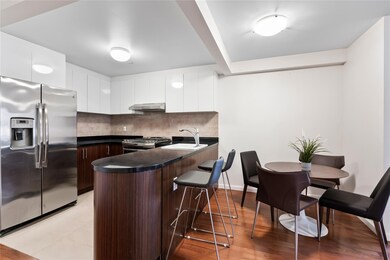 Kitchen with dark brown cabinetry, white cabinetry, range hood, backsplash, and appliances with stainless steel finishes