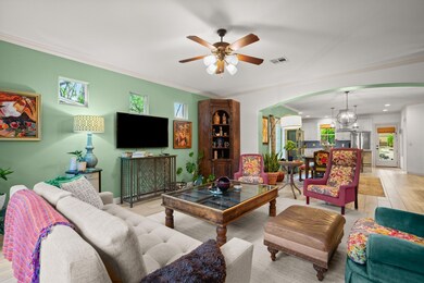 Living room with arched walkways, a ceiling fan, 
