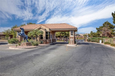 View of asphalt road with a gated entry, curbs, an