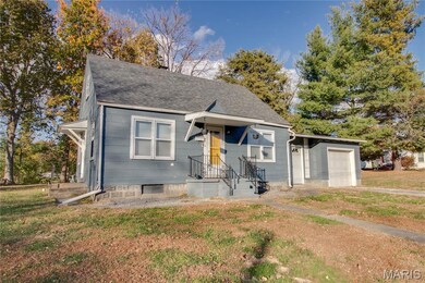 View of front facade with roof with shingles, a garage, and a front lawn