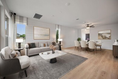 Living area with a ceiling fan, visible vents, an