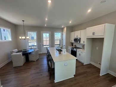 Kitchen with a center island, a chandelier, white cabinets, stainless steel appliances, and recessed lighting