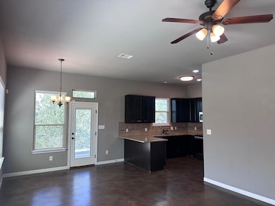 Kitchen featuring a peninsula, concrete flooring,