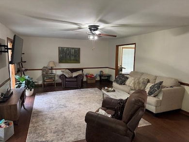 Living area with a ceiling fan and wood finished floors