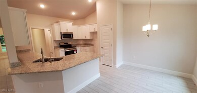 Kitchen featuring white cabinetry, kitchen peninsu