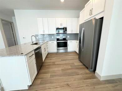 Kitchen with sink, stainless steel appliances, lig