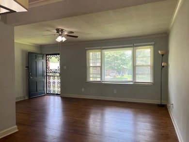 Spare room featuring ornamental molding, healthy amount of natural light, and dark wood-style floors