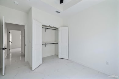 Unfurnished bedroom with light marble finish floors and a closet