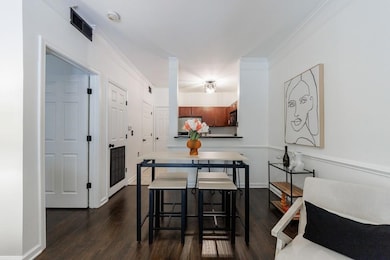 Dining space with ornamental molding and dark hard