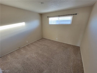 Unfurnished room featuring carpet flooring and a textured ceiling