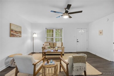 Living area featuring ceiling fan, dark wood-style