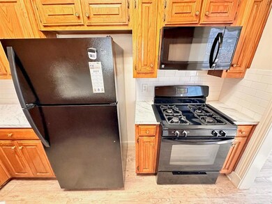 Kitchen featuring black appliances, backsplash, a