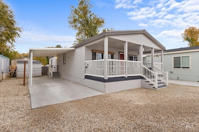 Manufactured / mobile home featuring a porch, a carport, and a shed