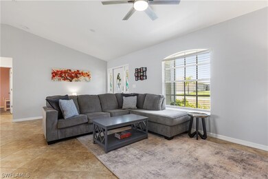 Living room with vaulted ceiling, ceiling fan, and