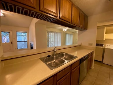 Kitchen with light countertops, dishwasher, a cei