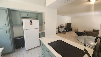 Kitchen with freestanding refrigerator, light woo