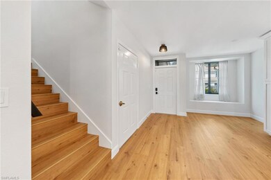 Entrance foyer featuring stairway, light wood-style flooring, and baseboards