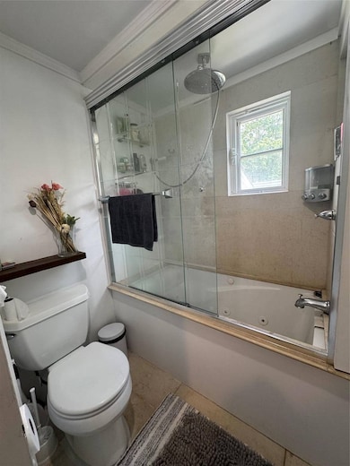 Bathroom featuring crown molding, a combined bath / shower with jetted tub, and tile patterned flooring