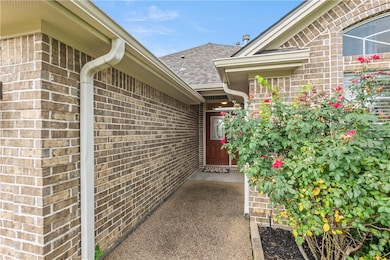 Property entrance with a shingled roof and brick s