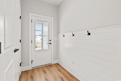 Mudroom with light wood-type flooring and baseboards