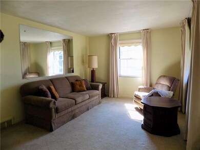Living room with hardwood floors under carpet.