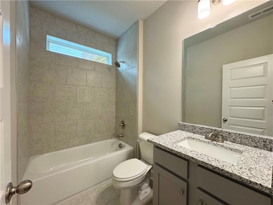Full bathroom featuring shower / bath combination, vanity, and tile patterned flooring