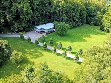 Tree-lined drive to house with a detached garage.