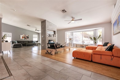Living area with a ceiling fan, vaulted ceiling, a
