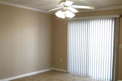 Empty room with crown molding, a ceiling fan, and 