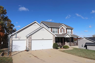 Traditional home with a porch, concrete driveway, and brick siding