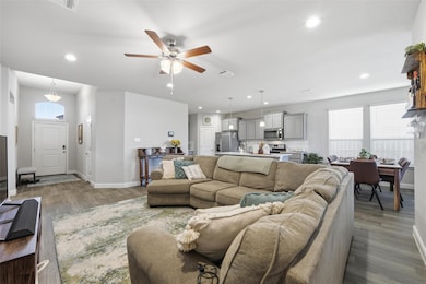 Living area featuring a ceiling fan, dark wood finished floors, and recessed lighting