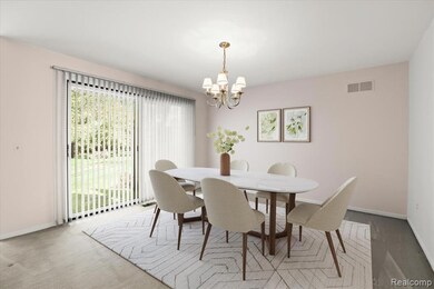 Carpeted dining space featuring patio door, and a chandelier